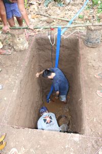 Alex and Ethan pumping out water of a really deep hole. There is the sand layer at the bottom of all that muck.